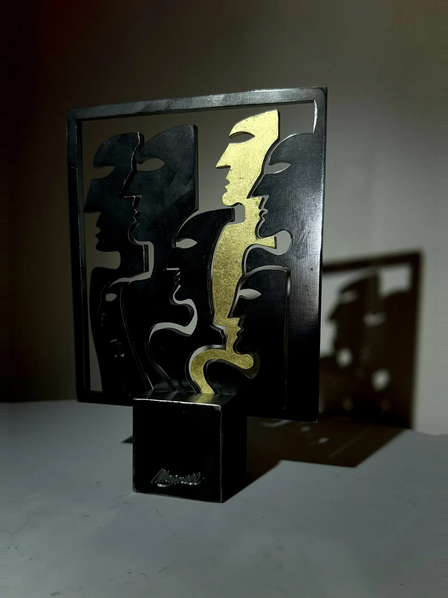 Cornice, sculpture de Gianluca Magnelli, profils entrelacés dans un cadre doré.