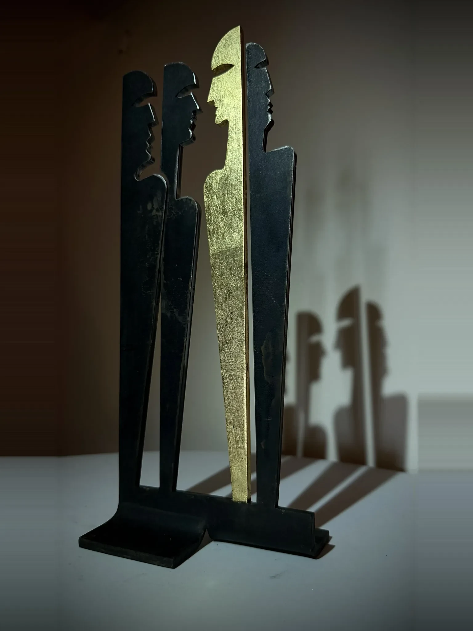 Corteo, sculpture de Gianluca Magnelli, figures ensemble, une en or.