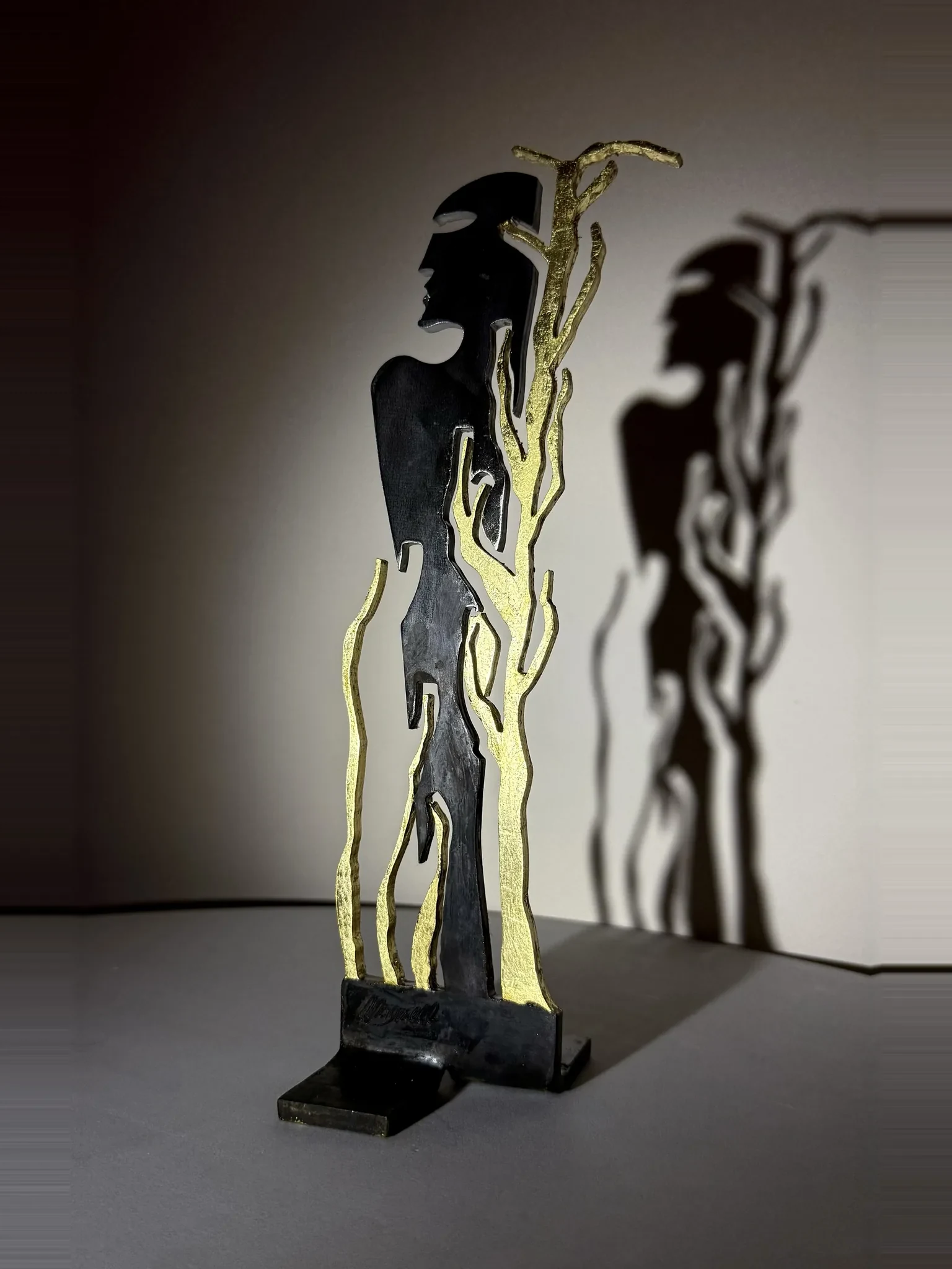 Tralcio, sculpture de Gianluca Magnelli, un profil et un rameau d’or.