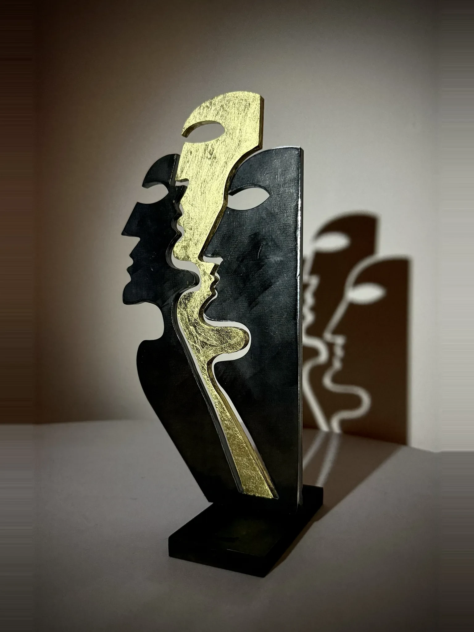 Tre profili, sculpture de Gianluca Magnelli, trois profils, or au centre.